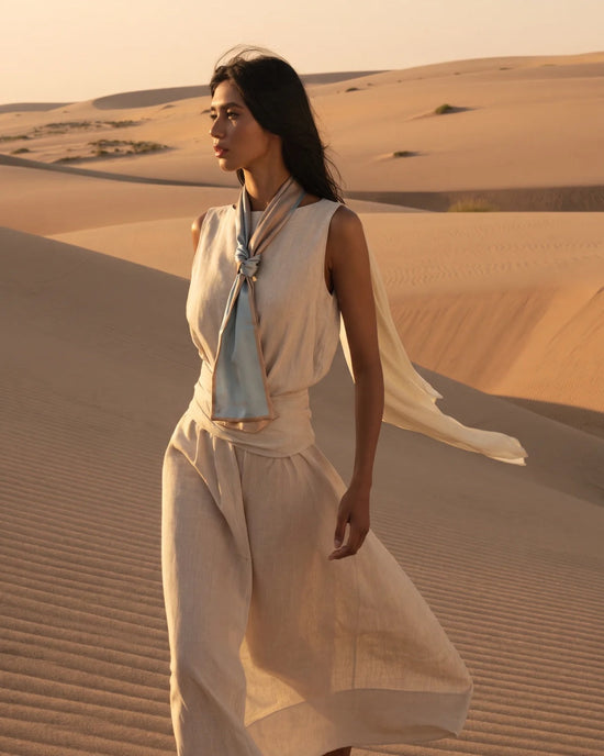 Karavata blue and cream silk tie styled with a light dress in desert scenery